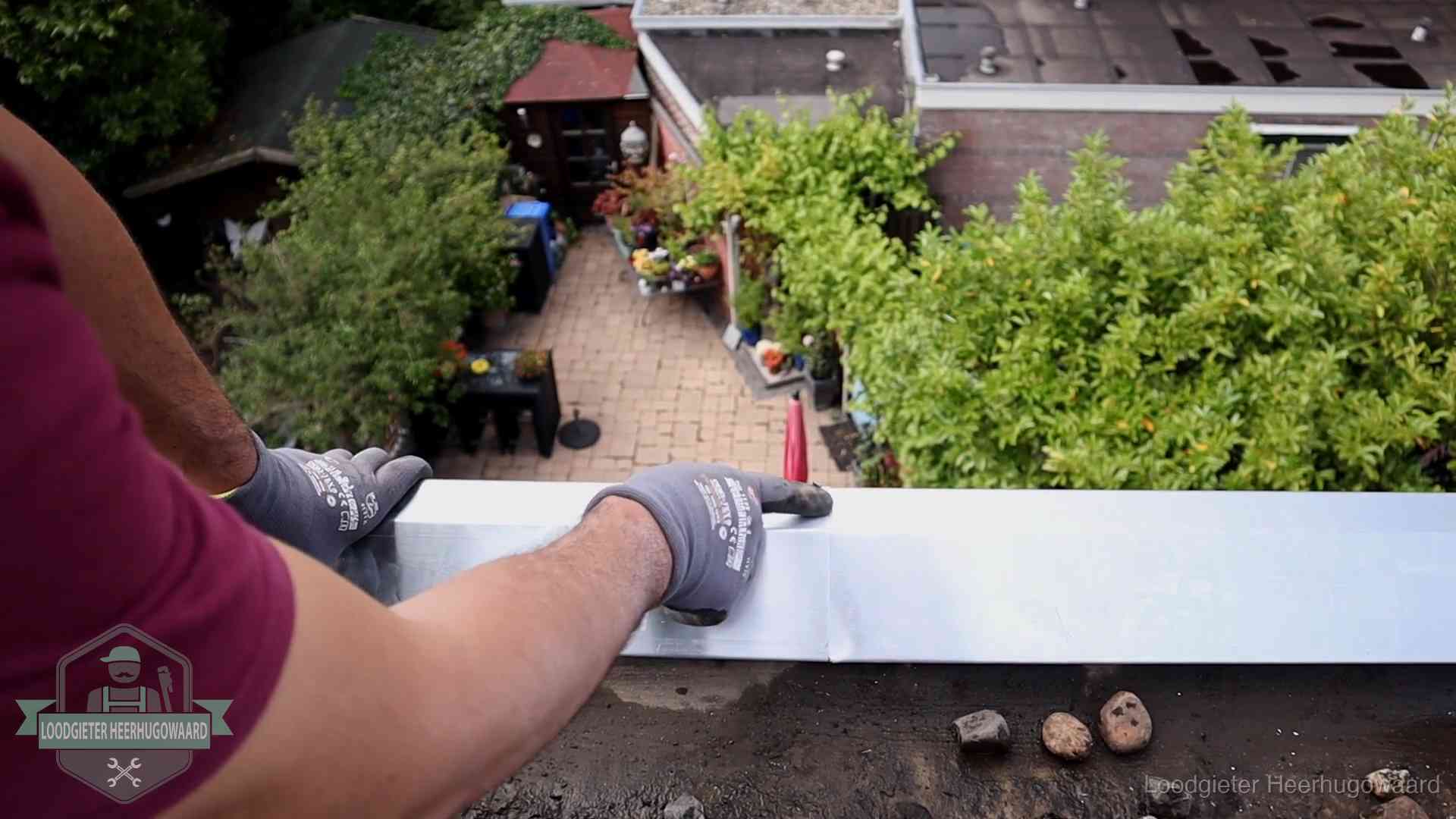 Daklekkage geregeld in Heerhugowaard Vakman plaatst een daktrim op de dakrand van een woning in Heerhugowaard