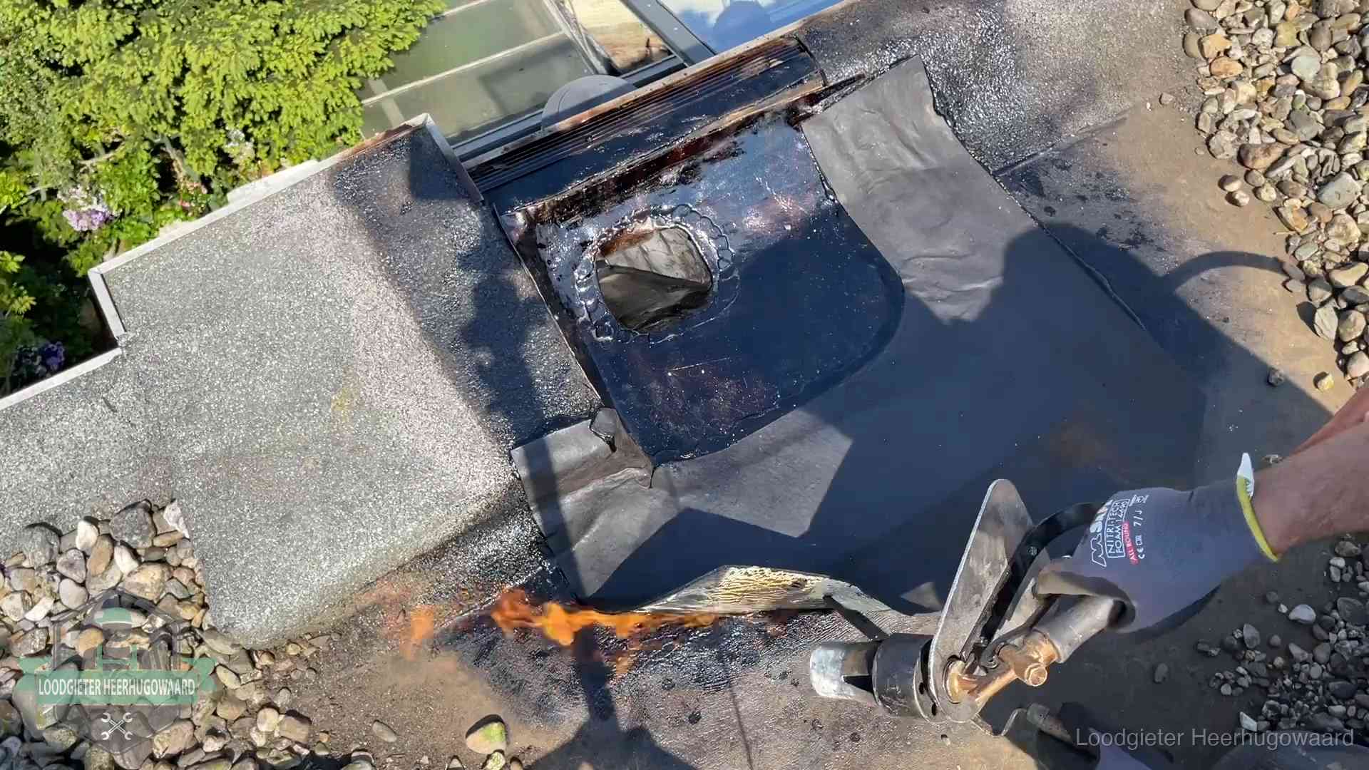 Daklekkage repareren in Heerhugowaard Dakdekker brandt bitumen rond een doorvoer tijdens een daklekkage-reparatie in Heerhugowaard