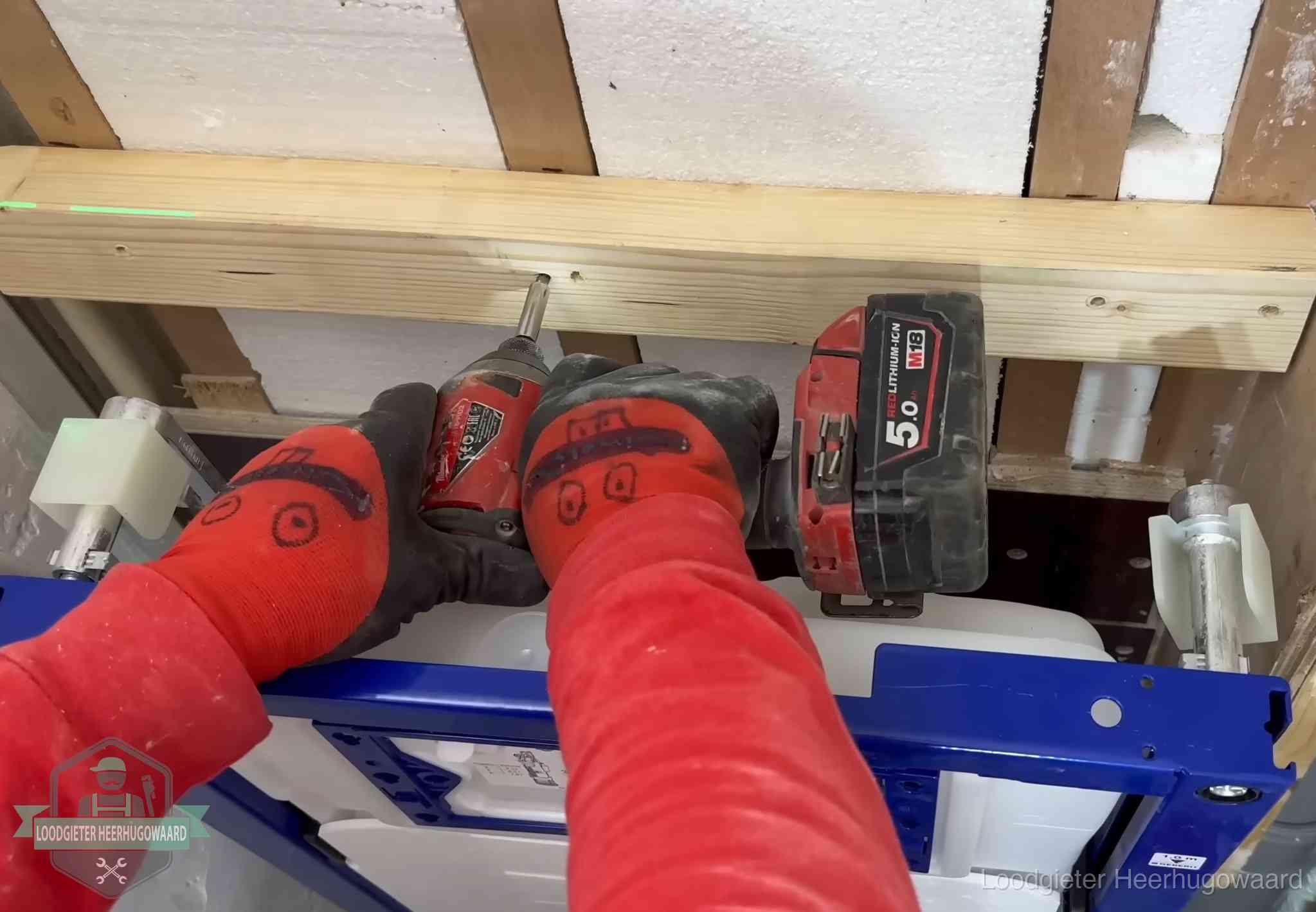 Monteur bevestigt een inbouwreservoir voor een hangend toilet in Heerhugowaard