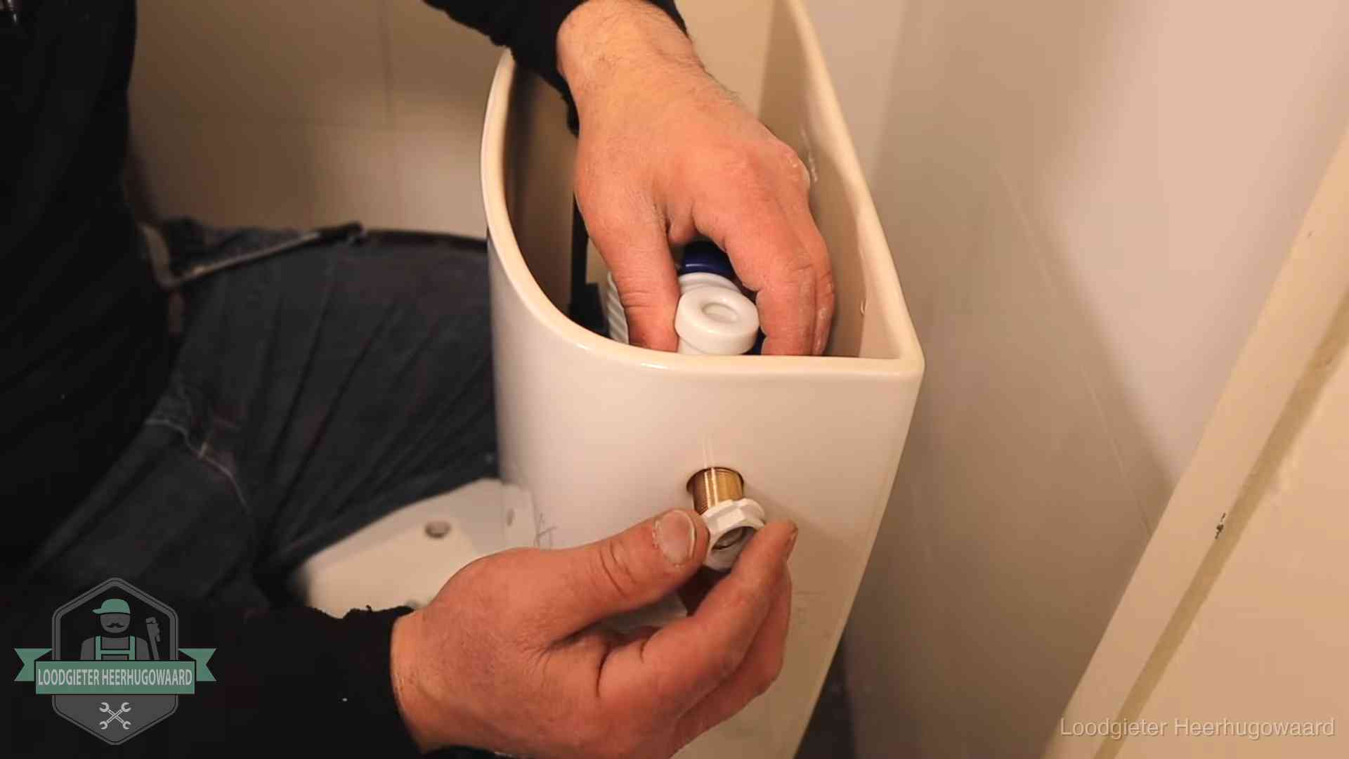 Loodgieter monteert de vlotterkraan van een stortbak bij een toilet in Heerhugowaard