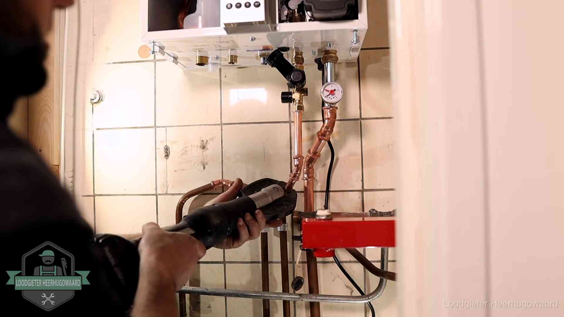 Cv-ketel onderhoud in Heerhugowaard Monteur werkt aan de leidingen onder een cv-ketel in Heerhugowaard