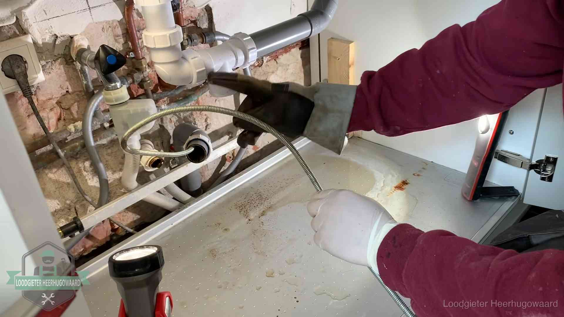 Spiraal of hogedruk in Heerhugowaard Ontstoppingsveer gaat in een geopende sifonaansluiting onder het aanrecht in Heerhugowaard