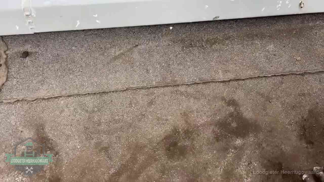 Stormschade en neerslag op daken in Heerhugowaard Vochtplekken bij de naad van een plat dak na aanhoudende regen in Heerhugowaard