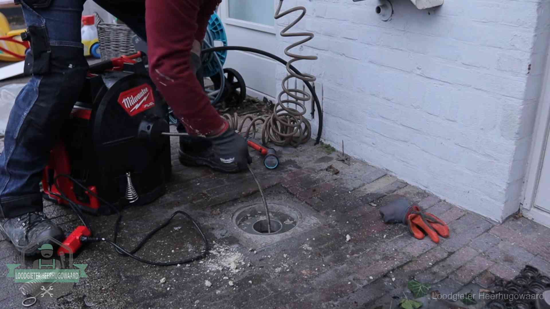 Prijs van een rioolontstopping in Heerhugowaard Spiraalmachine bij een ontstoppingsputje in de bestrating in Heerhugowaard