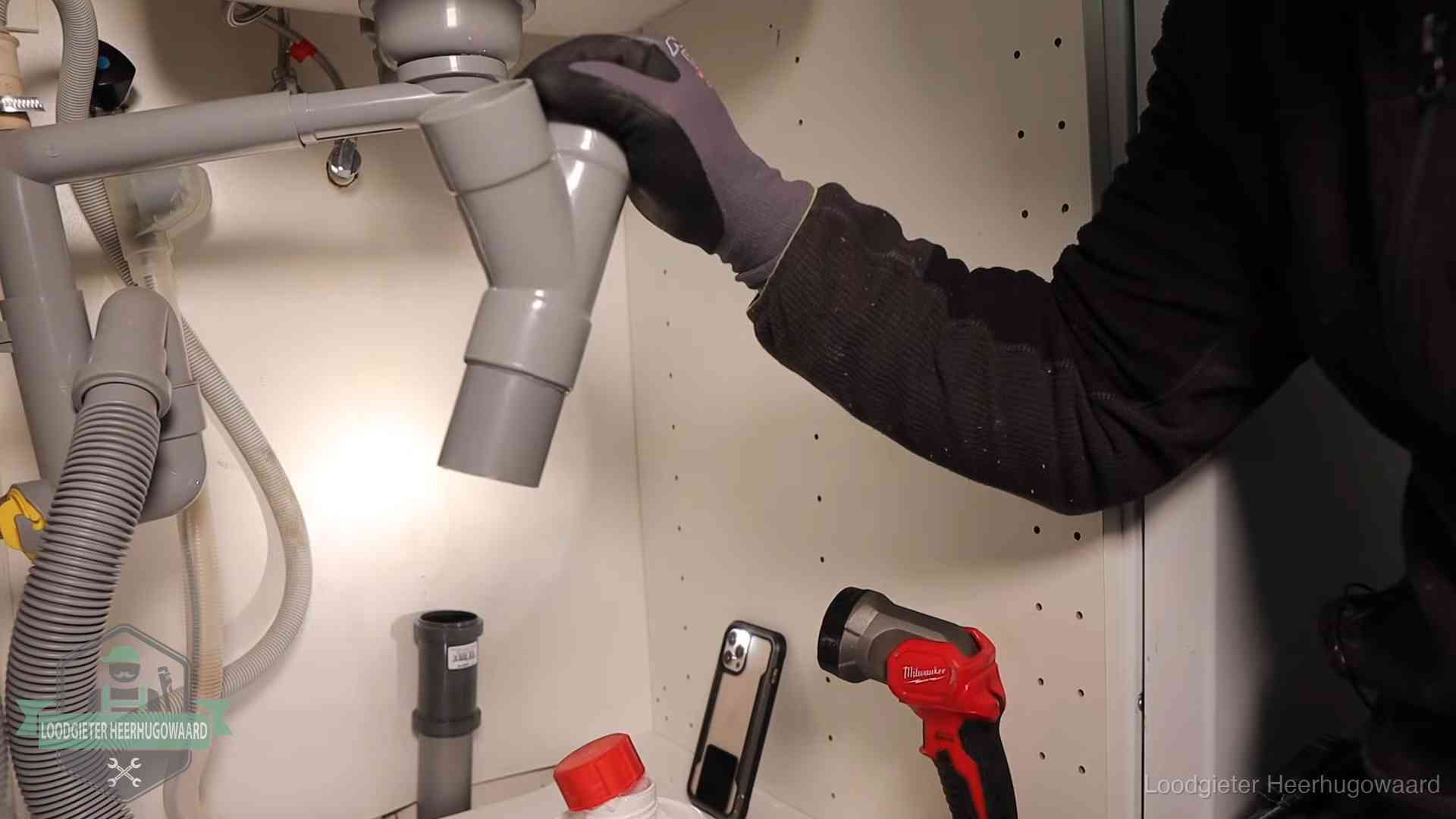 Rioollucht in huis verhelpen in Heerhugowaard Loodgieter demonteert het sifon- en afvoerwerk onder een gootsteen in Heerhugowaard bij stankklachten