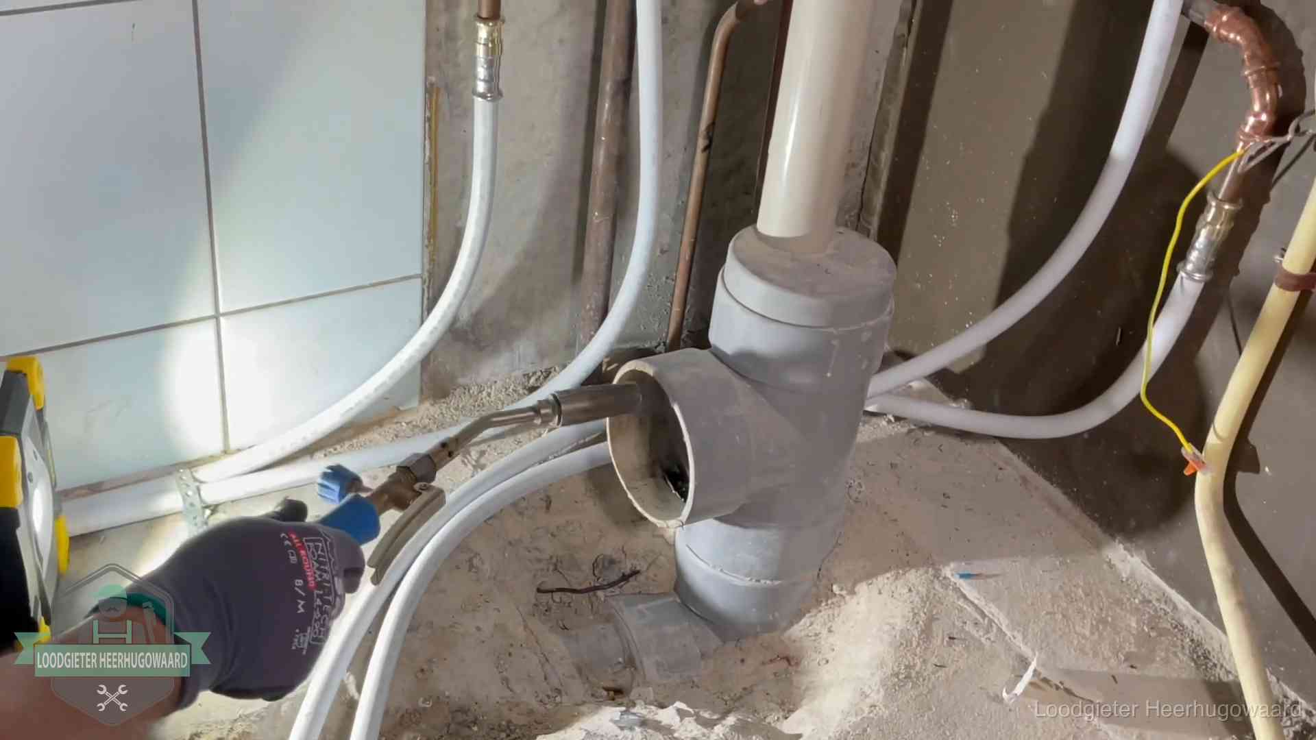 Verstopping in een huurwoning in Heerhugowaard Loodgieter werkt aan leidingen bij de pvc-standleiding van een huurwoning in Heerhugowaard
