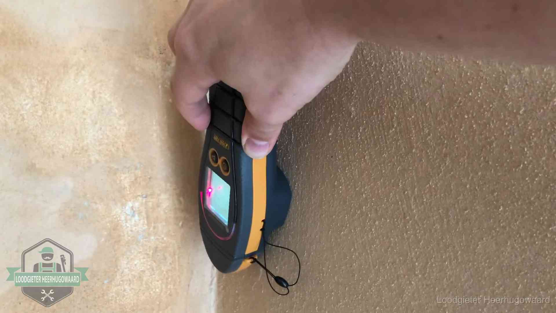 Daklekkage opsporen zonder hakwerk in Heerhugowaard Vochtmeter tegen een muur met vochtplekken tijdens het opsporen van een daklekkage in Heerhugowaard