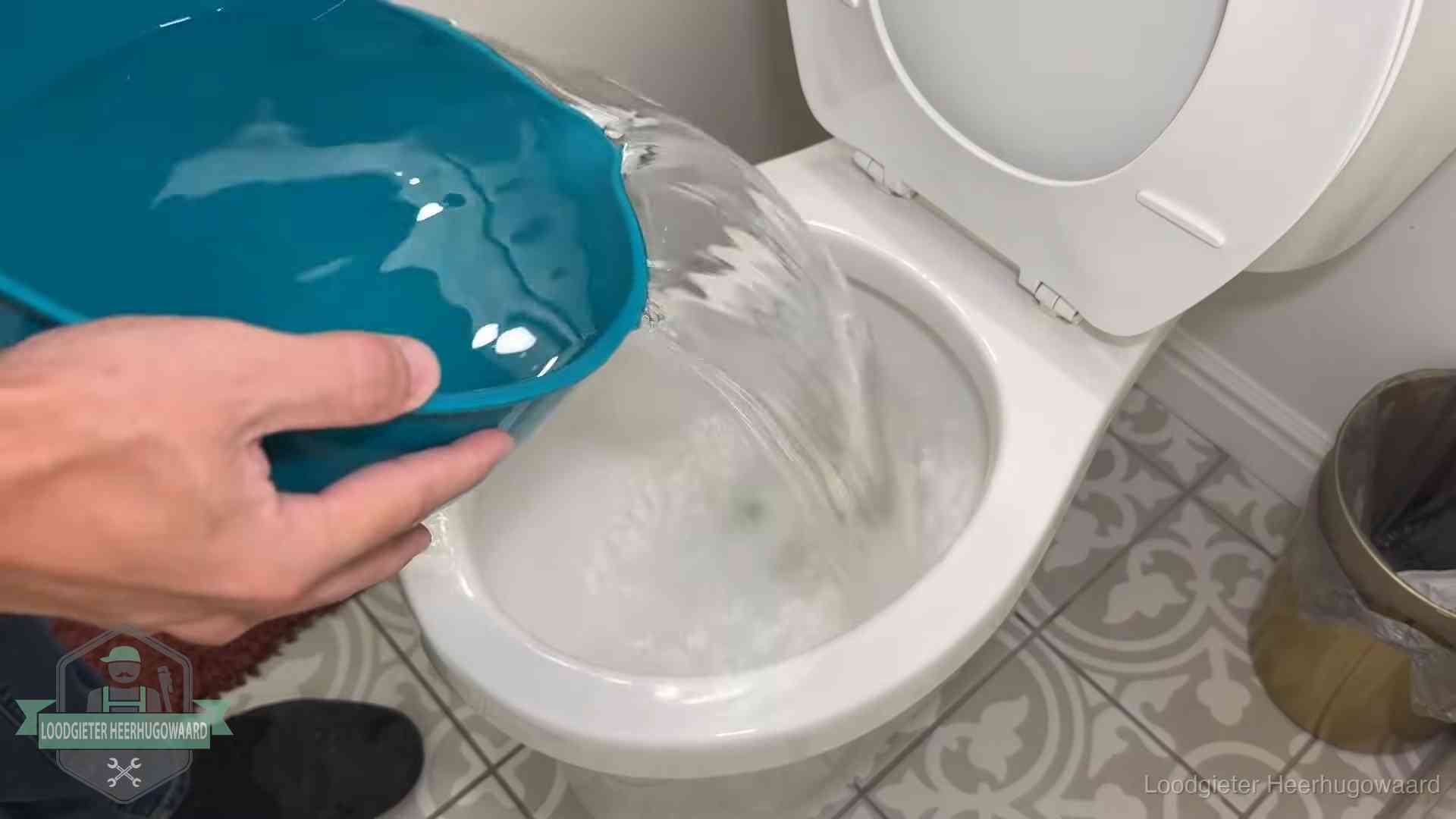 Warm water wordt voorzichtig in de wc-pot gegoten in Heerhugowaard