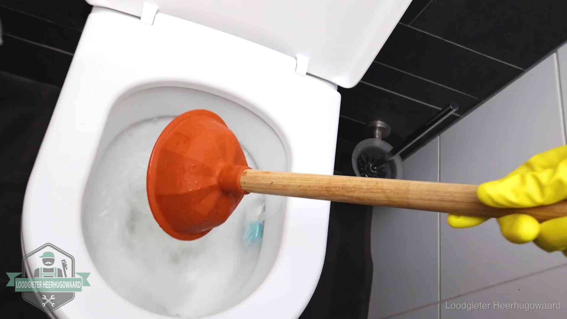 Plopper wordt in de wc-pot gedrukt bij het ontstoppen van een toilet in Heerhugowaard