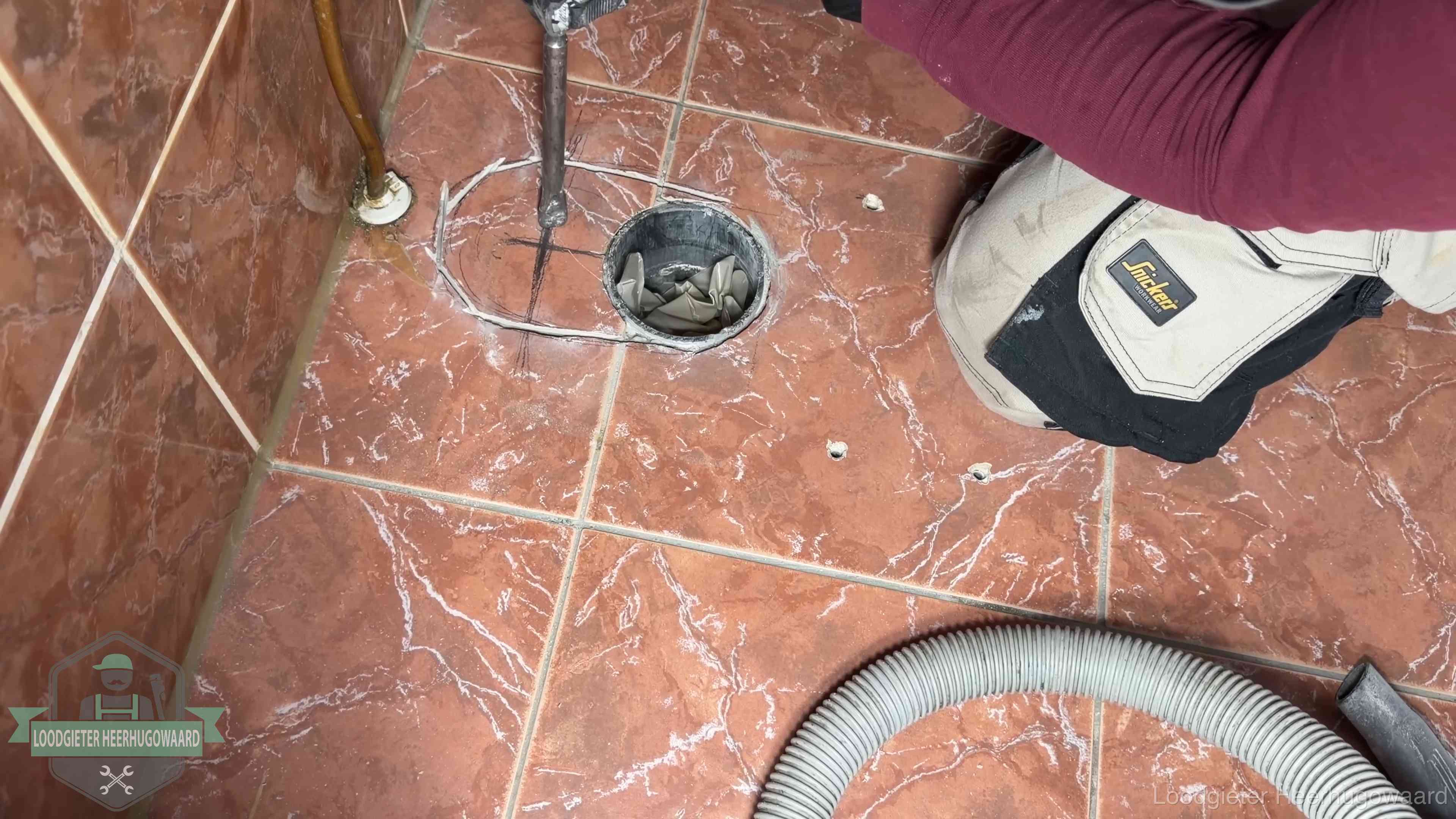 Open rioolaansluiting in de vloer waar de wc-pot is gedemonteerd in Heerhugowaard
