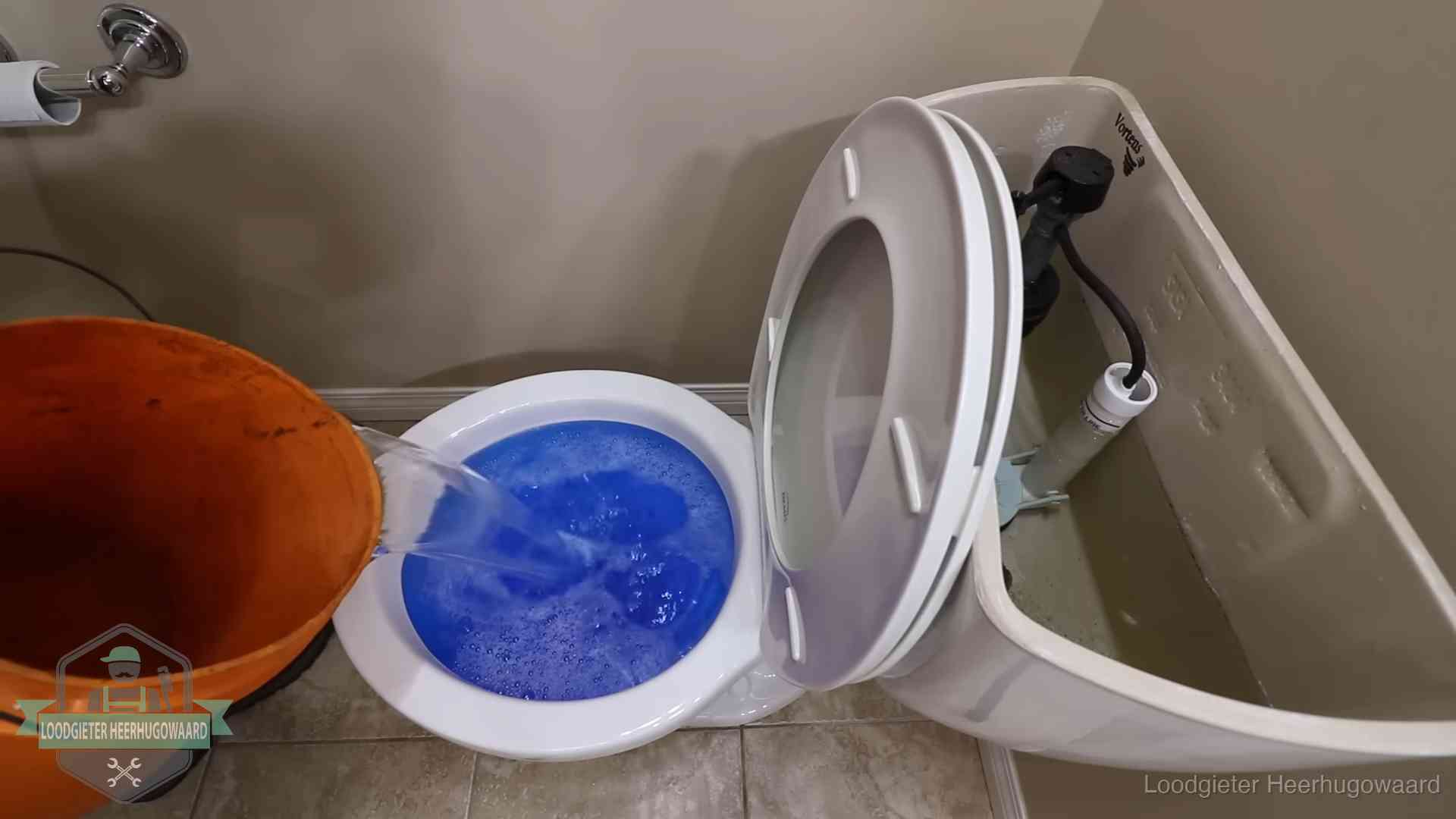 Water bij de wc-pot wordt met een emmer weggewerkt om schade te beperken in Heerhugowaard